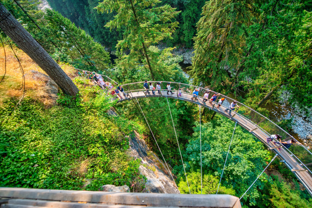 vancouver, canada august 11, 2017: people at capilano bridge. it is a suspension bridge crossing the capilano river, 140 metres long and 70 metres above the river.