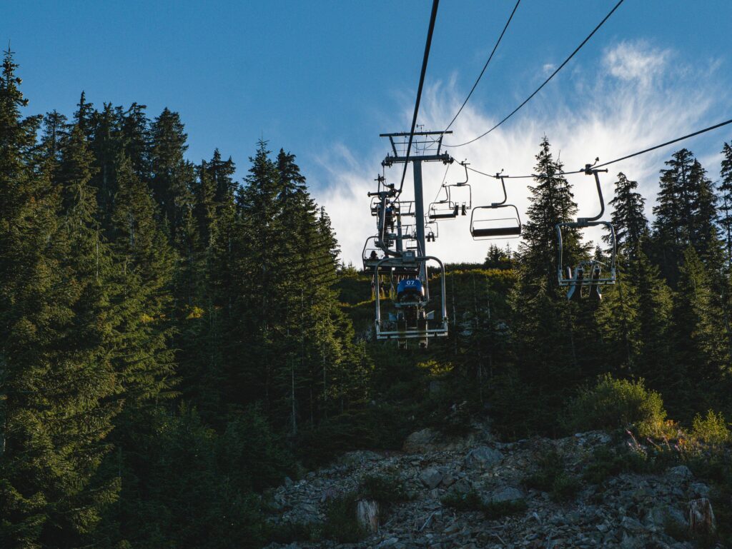 Visitors riding the Peak Chairlift at Grouse Mountain surrounded by alpine forest near Vancouver, British Columbia.