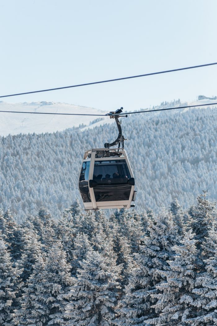 A cable car traverses a snow-covered landscape in Bursa, Türkiye, during winter.