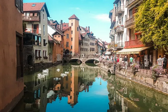 Picturesque canal in Annecy Old Town with colorful historic buildings, a stone bridge and waterfront restaurants
