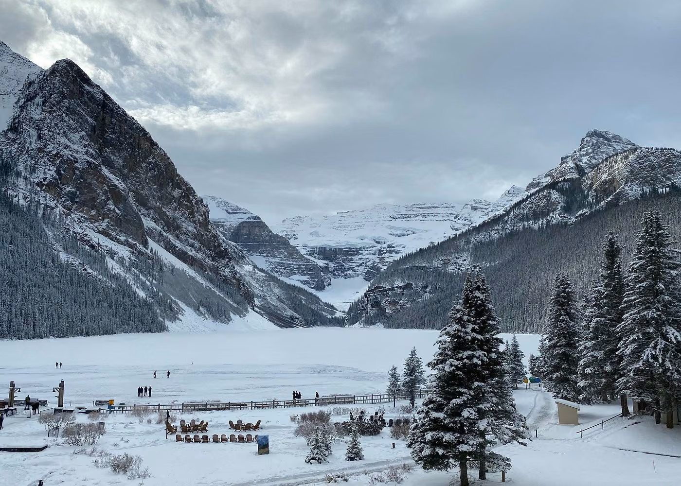 Frozen Lake Louise surrounded by snow-covered mountains and evergreen trees in Banff National Park