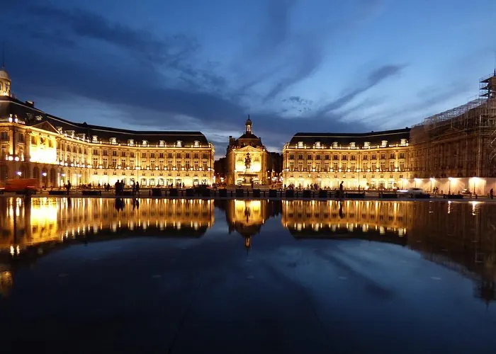 Illuminated Place de la Bourse reflected in the Miroir d'Eau in Bordeaux at dusk