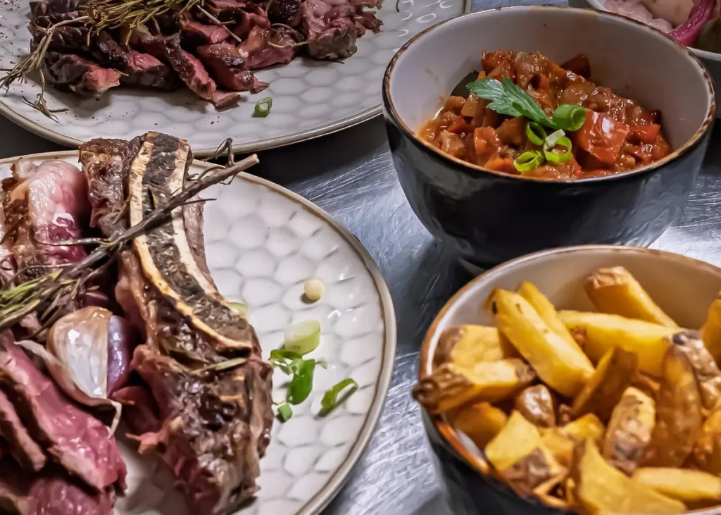 Assortment of roasted meat, golden potato wedges and vegetable dishes illustrating a Cannes food tour