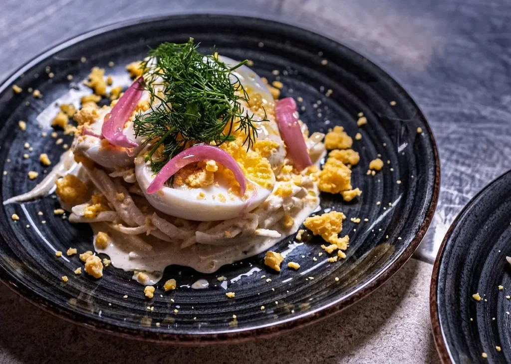 Gourmet egg dish with fresh dill and pickled red onions, illustrating Mediterranean cuisine on a Cannes food tour