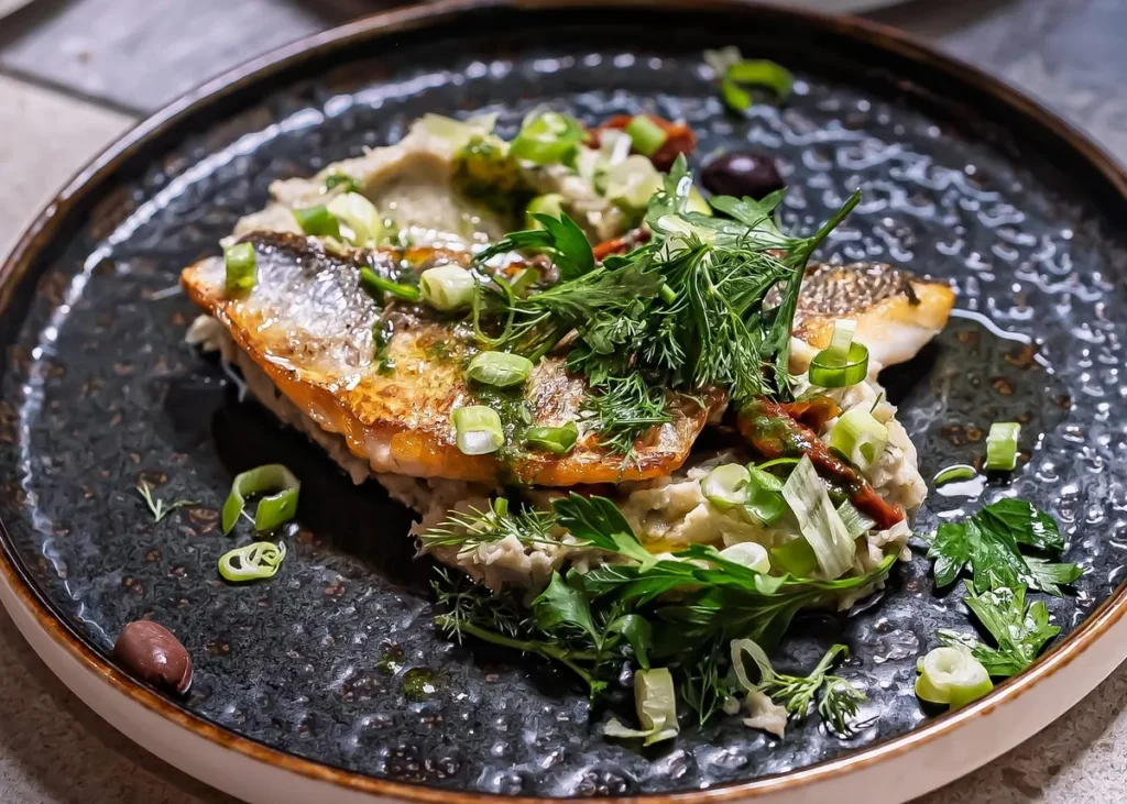 Mediterranean fish dish with fresh herbs and vegetables, illustrating local cuisine on a Cannes food tour