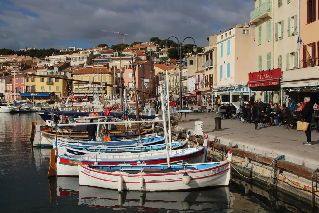 Traditional fishing boats moored in Cassis harbor beside colorful waterfront buildings and cafés