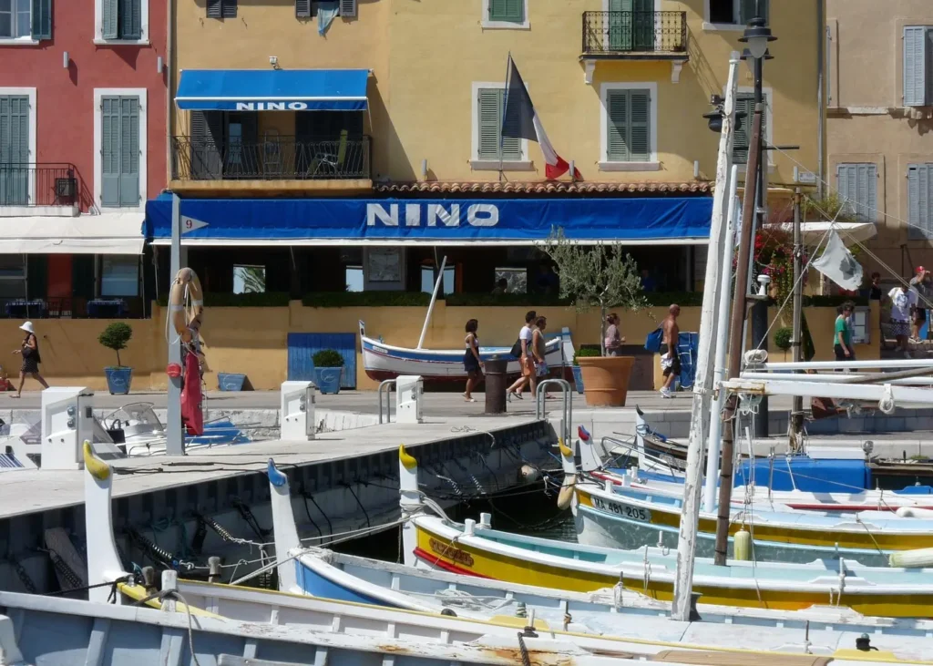 Traditional fishing boats moored in Cassis harbor beside colorful waterfront buildings in Provence