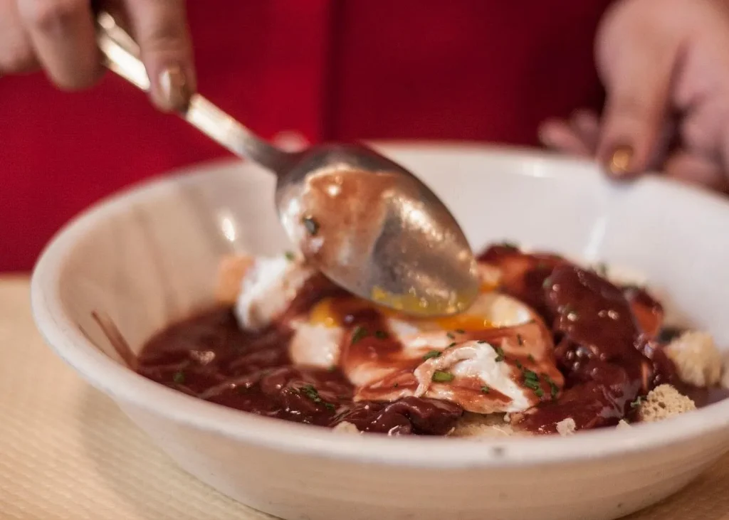 Traditional French dish with rich sauce being served during a Lyon food tasting experience