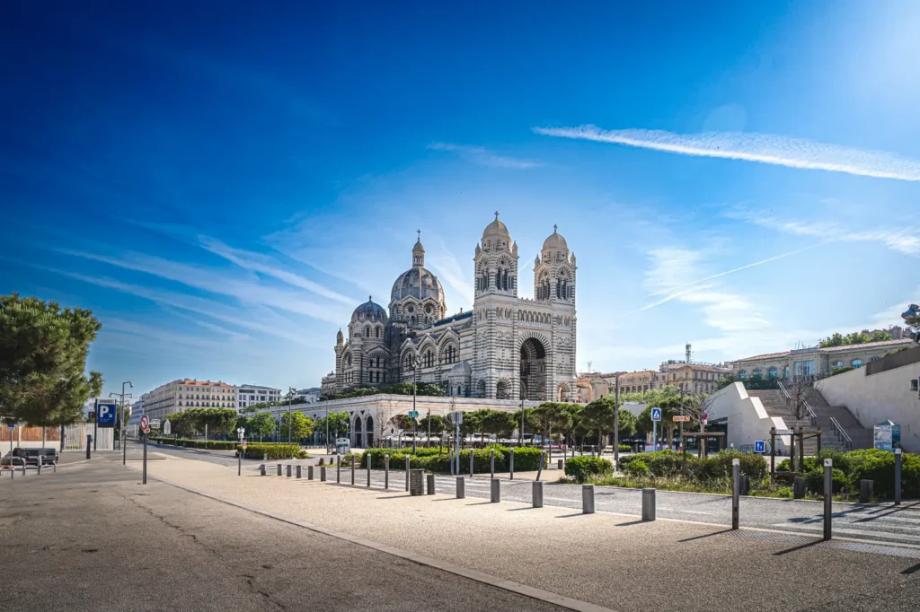 Cathédrale La Major in Marseille with its striped stone facade and twin towers under a blue sky