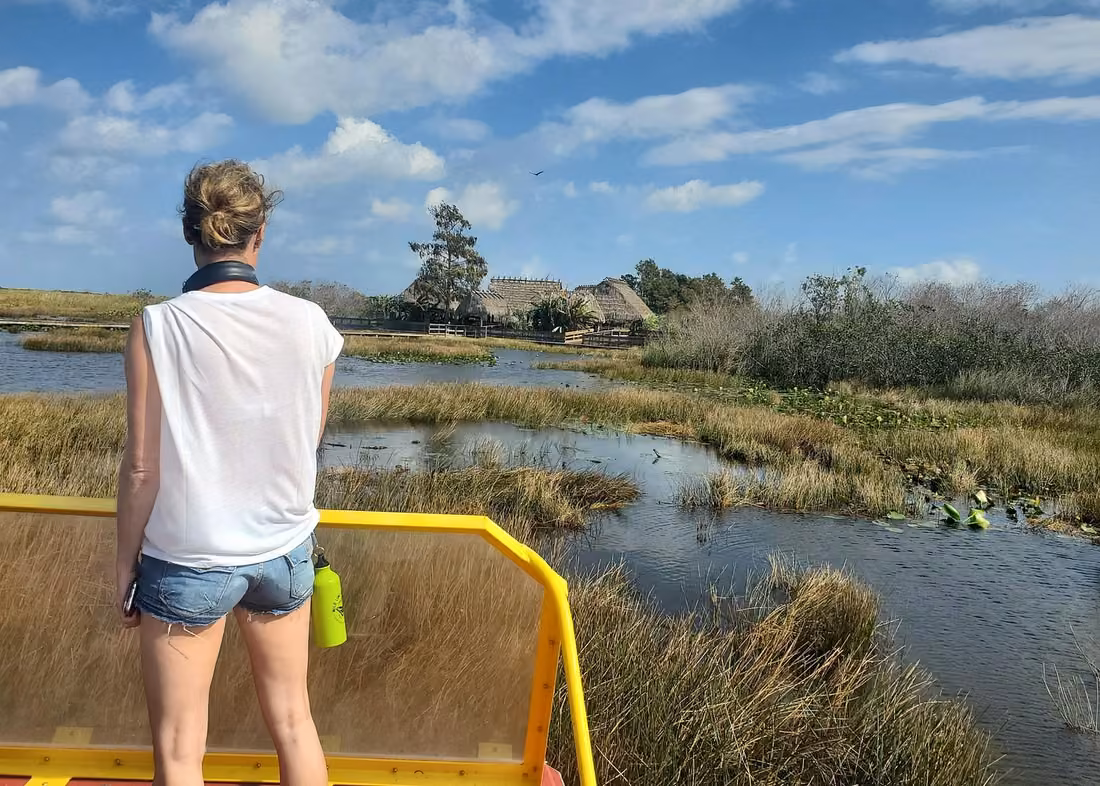 Visitor overlooking marshes and waterways from an airboat during an Everglades nature tour in Florida