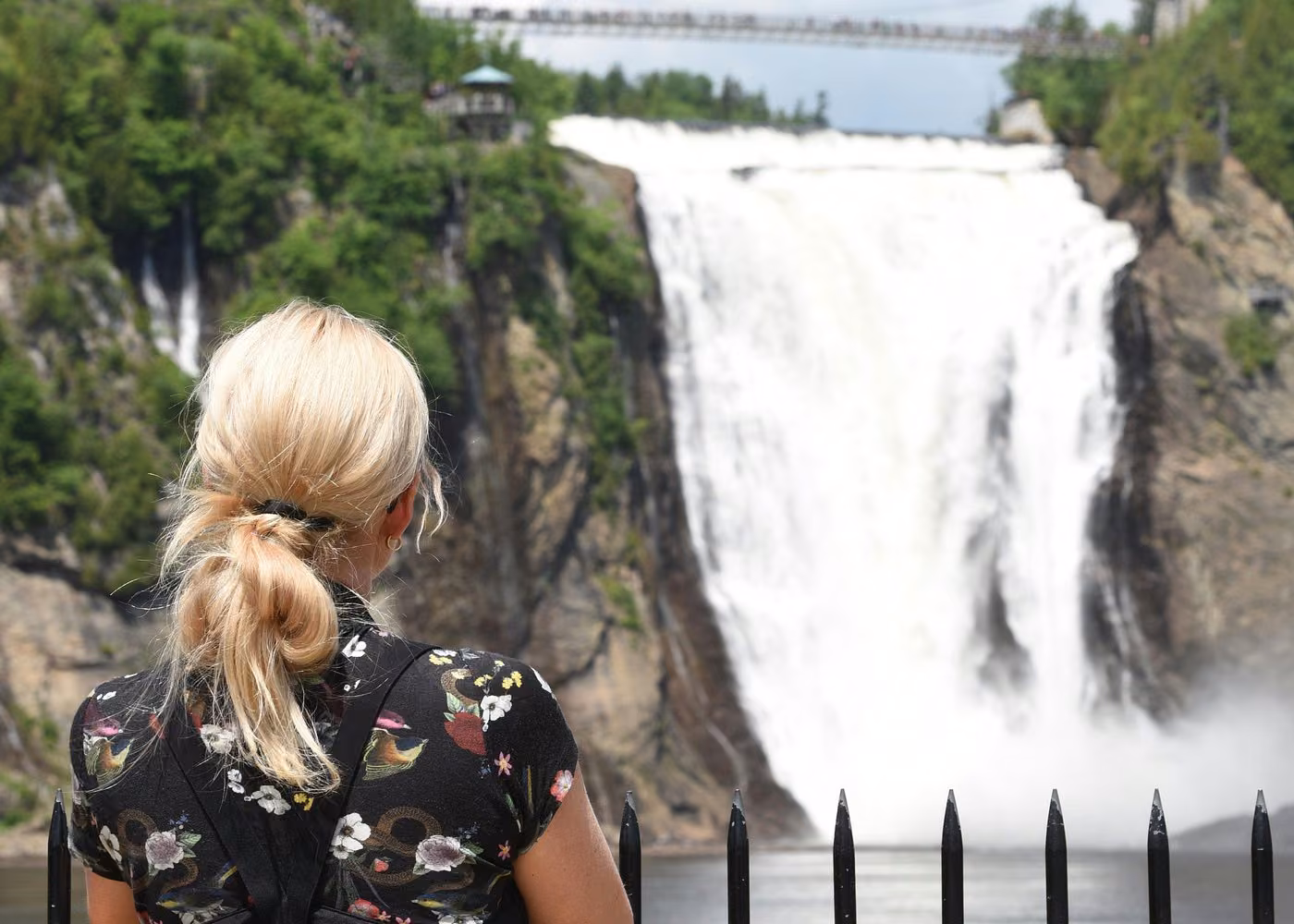 Visitor admiring Montmorency Falls from a scenic viewpoint near Quebec City