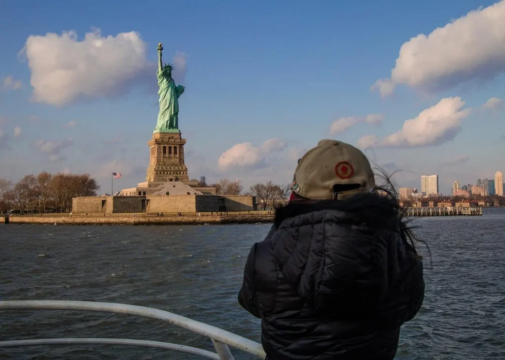 Traveler viewing the Statue of Liberty from a ferry in New York Harbor