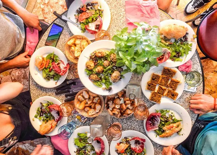 Overhead view of a shared table filled with savory dishes, salads and pastries during a group meal