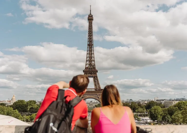 Two travelers admiring the Eiffel Tower during a Paris in a Day sightseeing tour