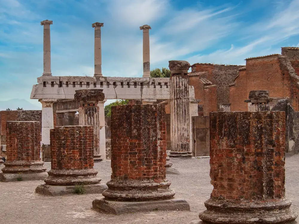 Ancient Roman columns and brick ruins at the Pompeii archaeological site in Italy