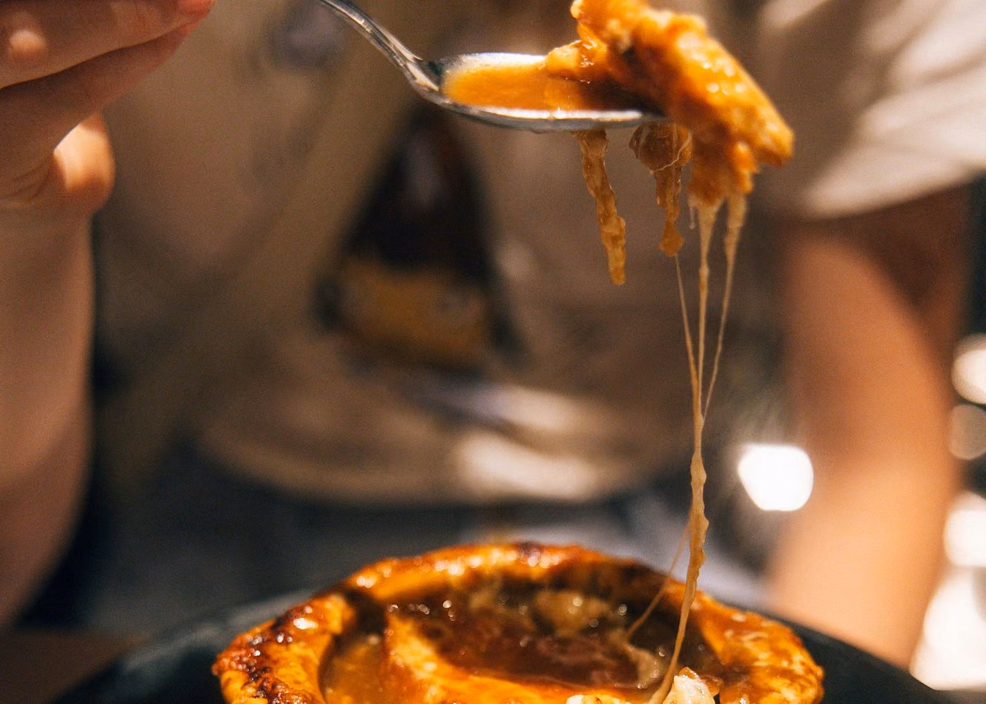 Melted cheese stretching from a gourmet dish during a fine dining experience