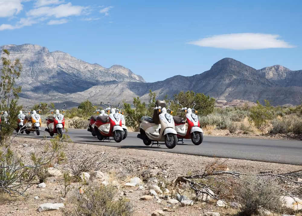 Motor scooters parked along a scenic desert road with rugged mountains at Red Rock Canyon near Las Vegas