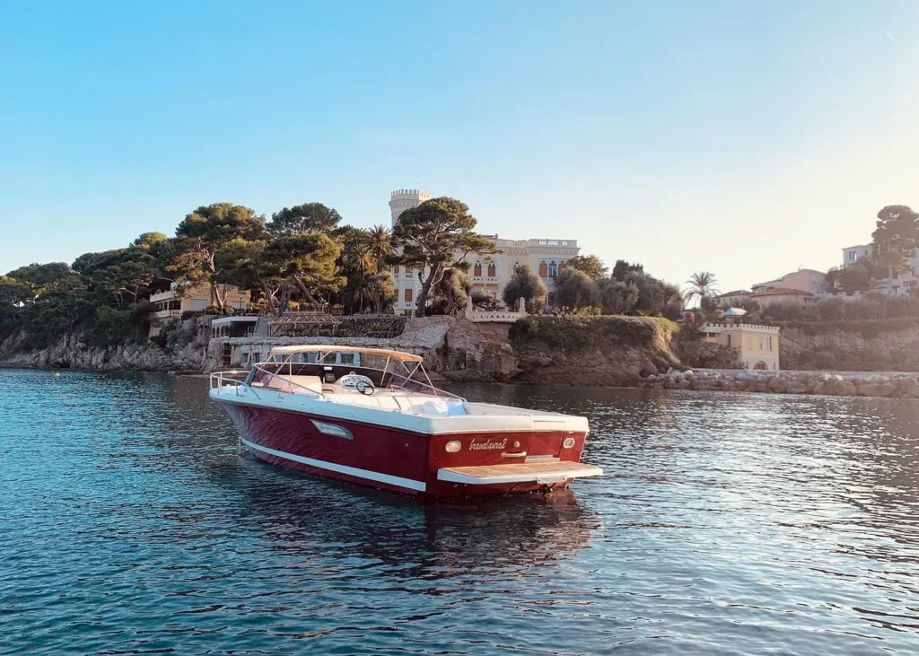 Private luxury motorboat cruising near the rocky coastline of the French Riviera