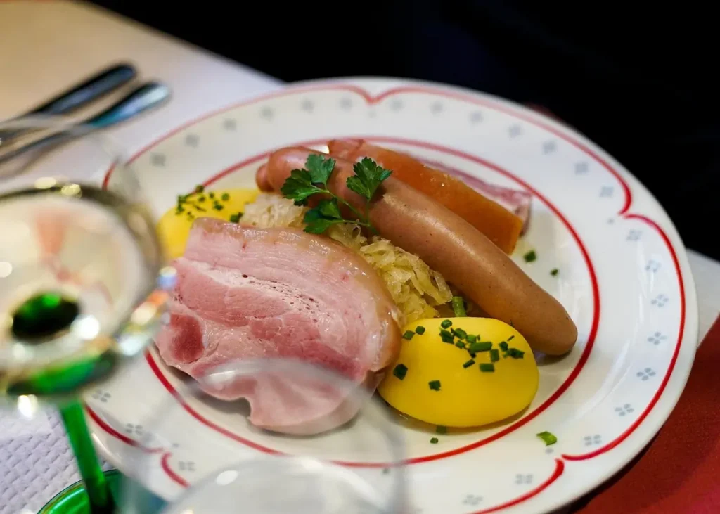 Traditional Alsatian choucroute garnie with sausages, smoked pork, sauerkraut and potatoes served on a plate