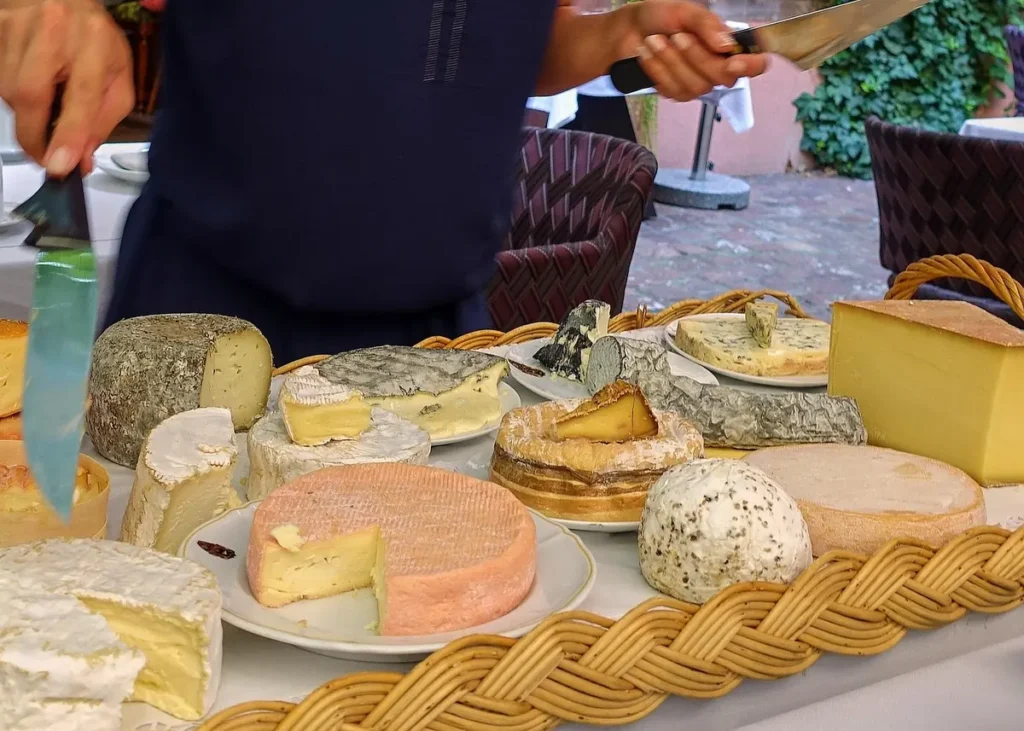 Selection of artisan cheeses displayed on a market stall, including soft, hard and blue cheeses