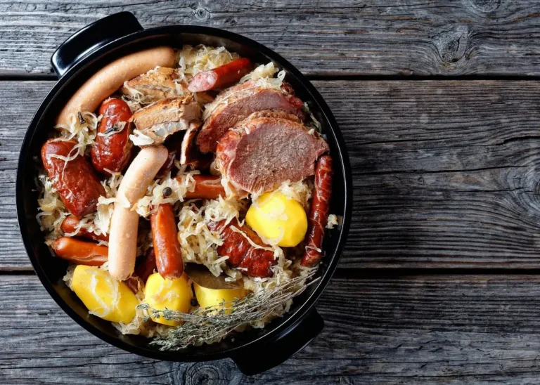 Traditional Alsatian choucroute garnie with assorted sausages, pork, sauerkraut and potatoes in a black serving dish