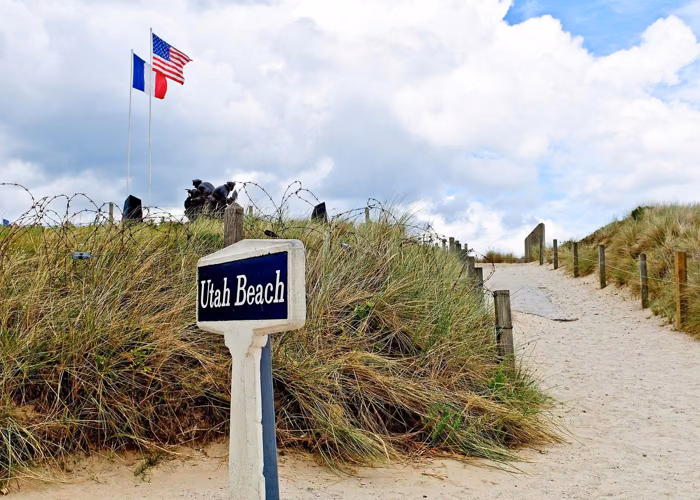 Utah Beach in Normandy with French and American flags, a historic stop on a D-Day tour from Paris