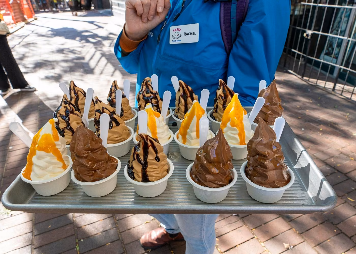 Assorted chocolate and vanilla soft serve ice cream cups with caramel and chocolate toppings on a Vancouver food tour