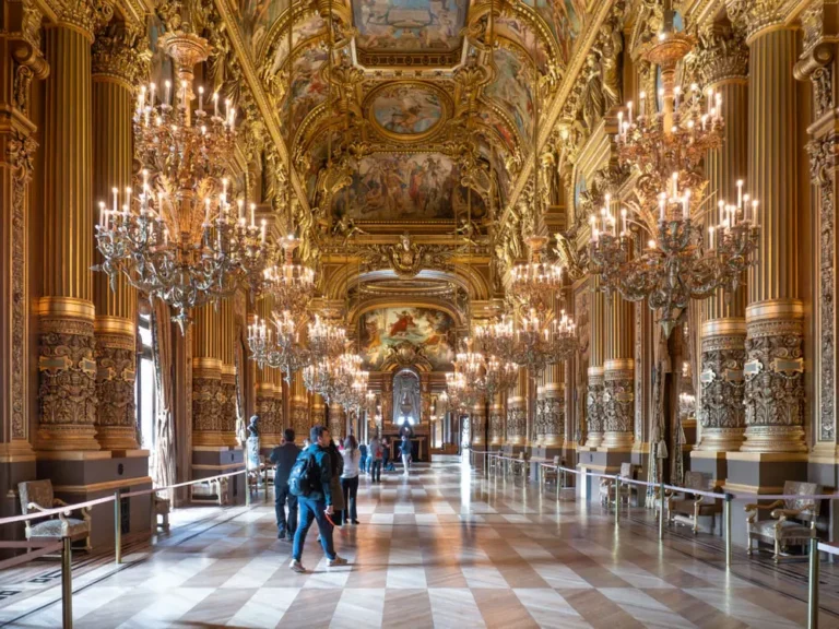 Grand Foyer of the Palais Garnier in Paris with ornate chandeliers, gilded columns and painted ceilings