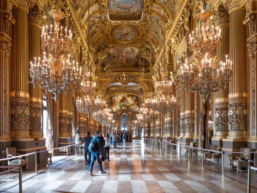 Grand Foyer of the Palais Garnier in Paris with ornate chandeliers, gilded columns and painted ceilings
