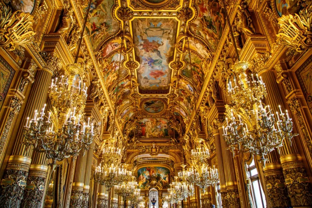 Ornate gilded interior with chandeliers and painted ceiling at the Palace of Versailles